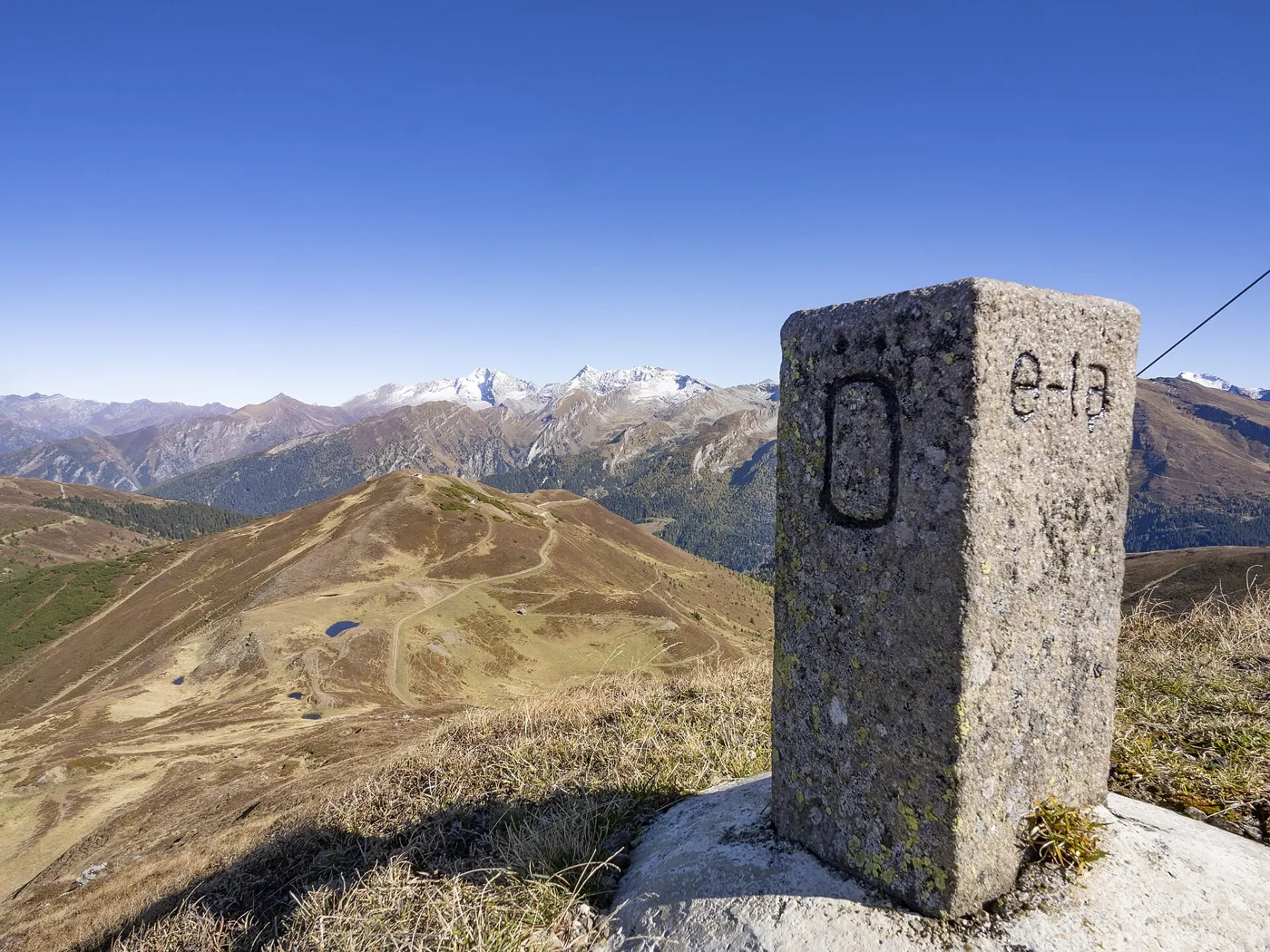 Borne frontière entre l'Autriche et l'Italie, posée en 1920 au sommet du Kreuzjoch, dans les Alpes de Stubai, à quelques kilomètres à l'ouest du Brenner ; à l'arrière-plan, les Alpes de Zillertal.