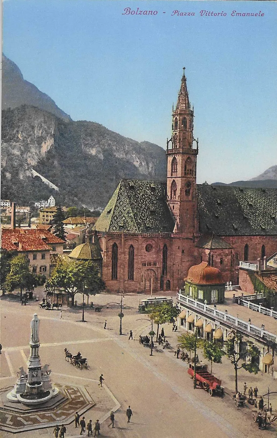 Carte postale des années 1920 : la Waltherplatz de Bolzano, rebaptisée « piazza Vittorio Emanuele », avec la statue de Walther von der Vogelweide et l'église paroissiale, aujourd'hui cathédrale.